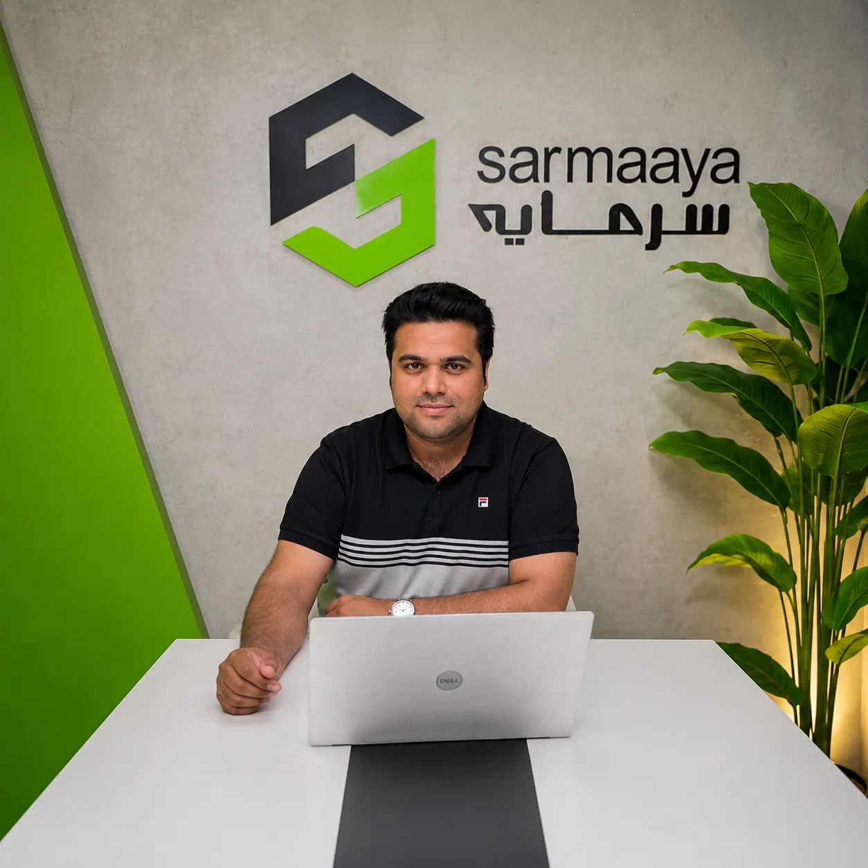 Salman Rasheed at the Sarmaaya office in Islamabad, seated at a desk with a laptop.